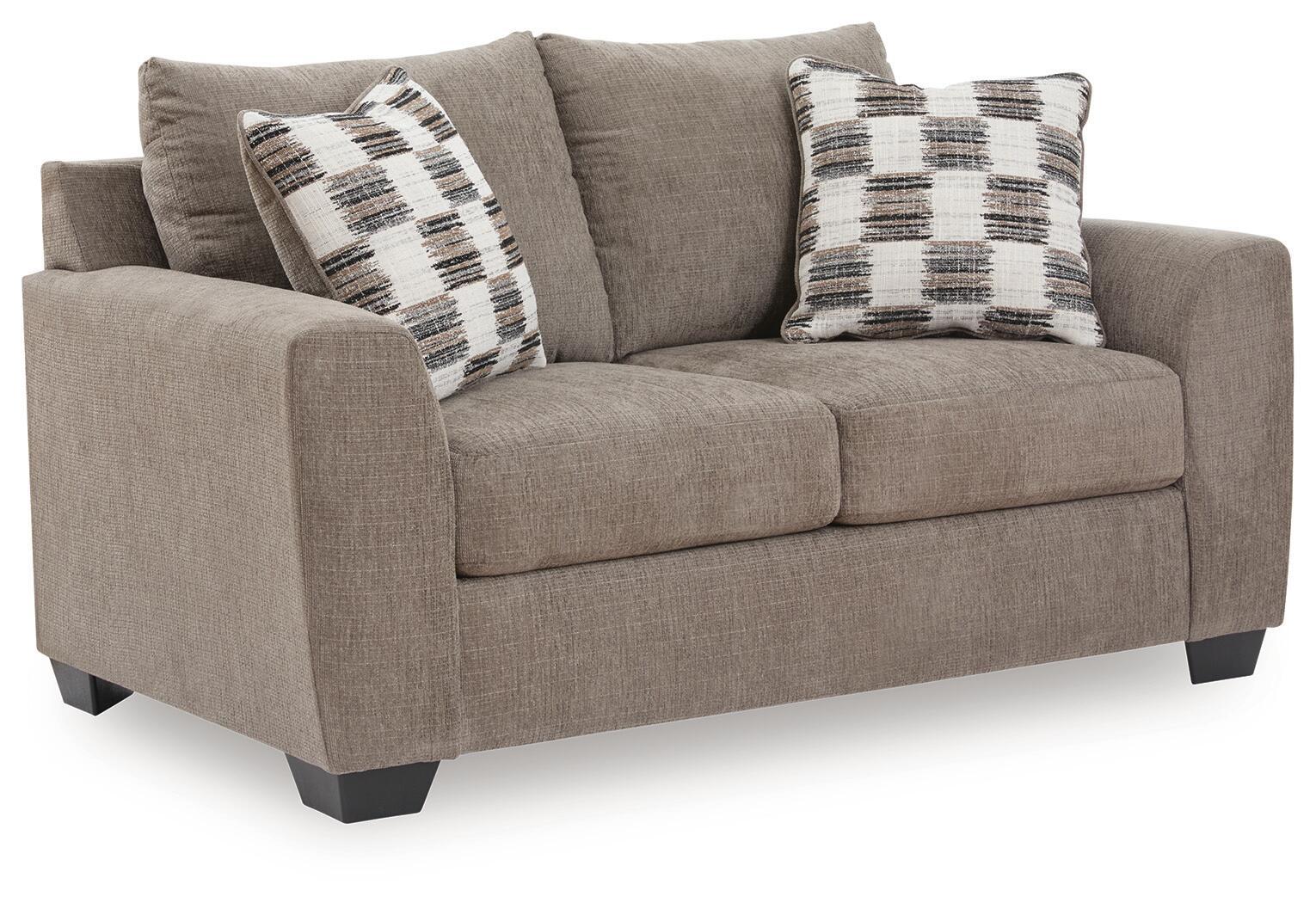 Light brown loveseat with two plaid throw pillows and cushioned arms