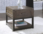 Gray-brown end table with drawer and lower shelf, styled with items on top.