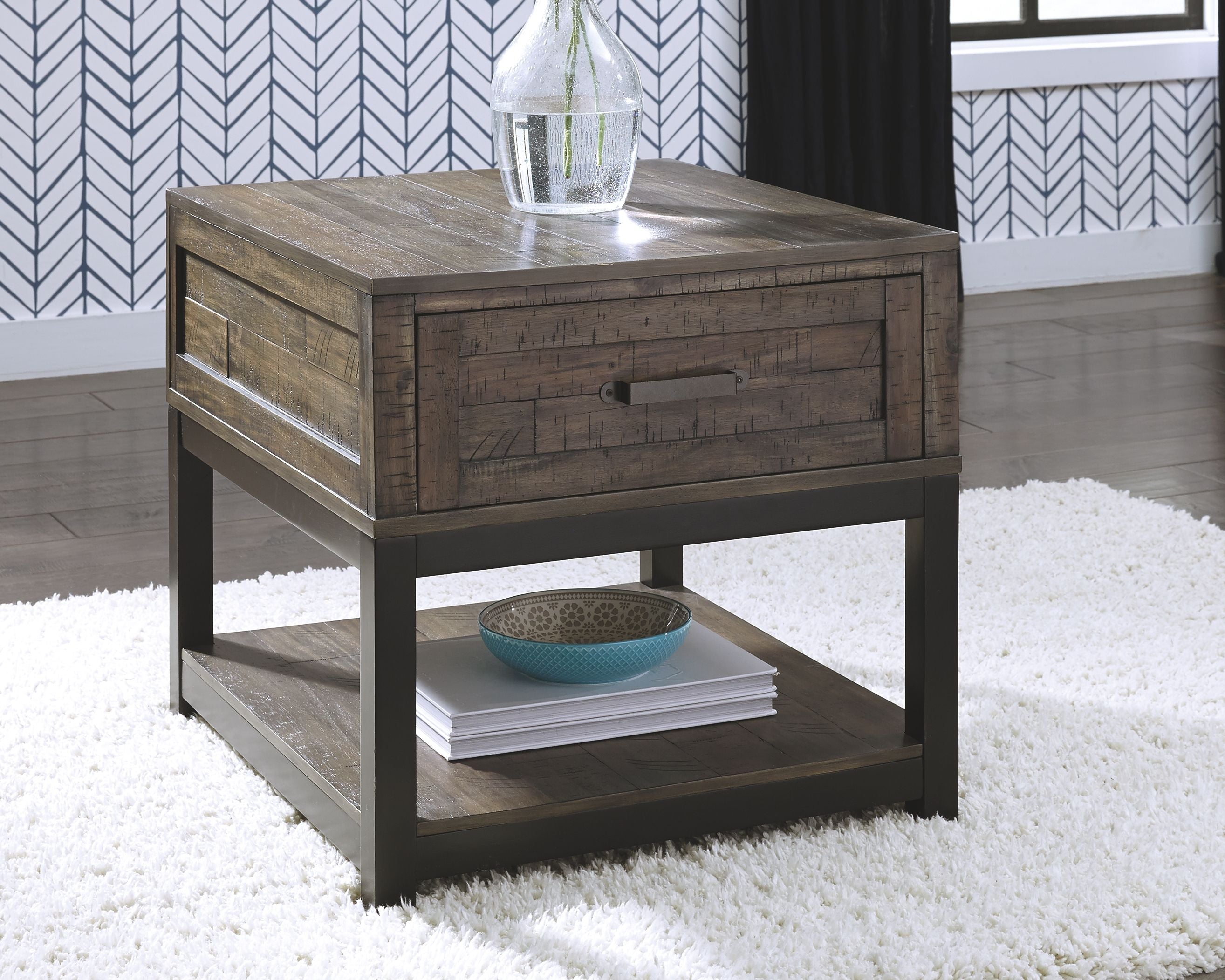 Gray-brown end table with drawer and lower shelf, styled with items on top.