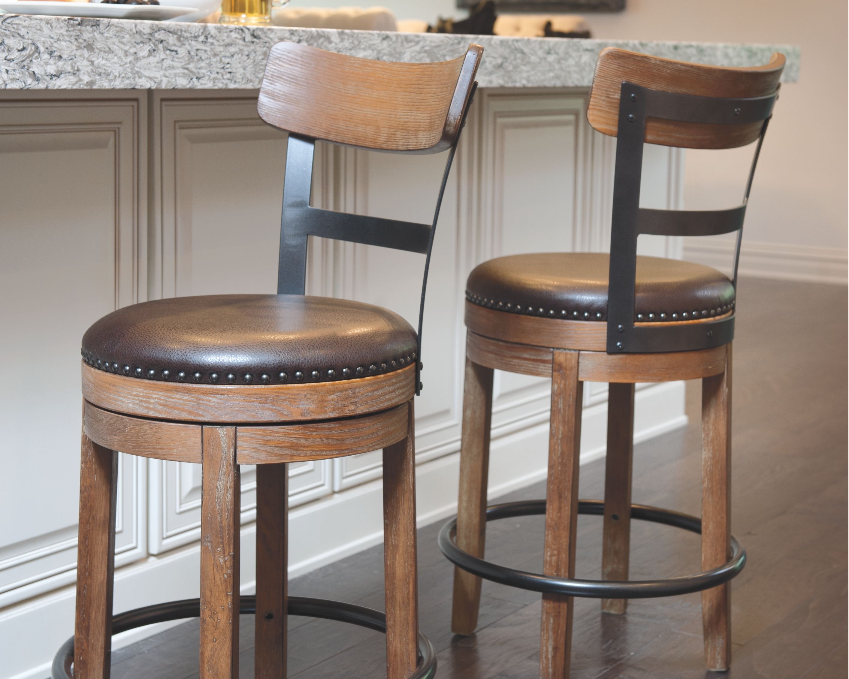 Swivel barstool with dark brown round seat, light brown wood legs, and black swivel ring