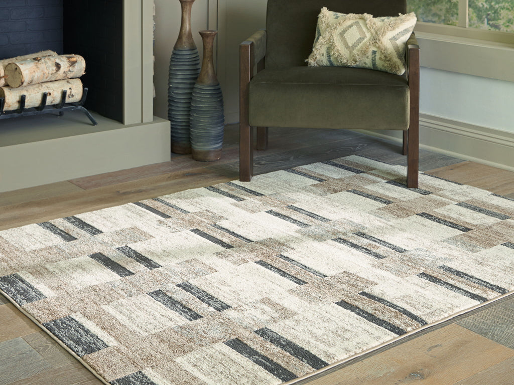 Beige abstract geometric area rug with dark gray blocks and textured weave