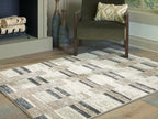 Beige abstract geometric area rug with dark gray blocks and textured weave