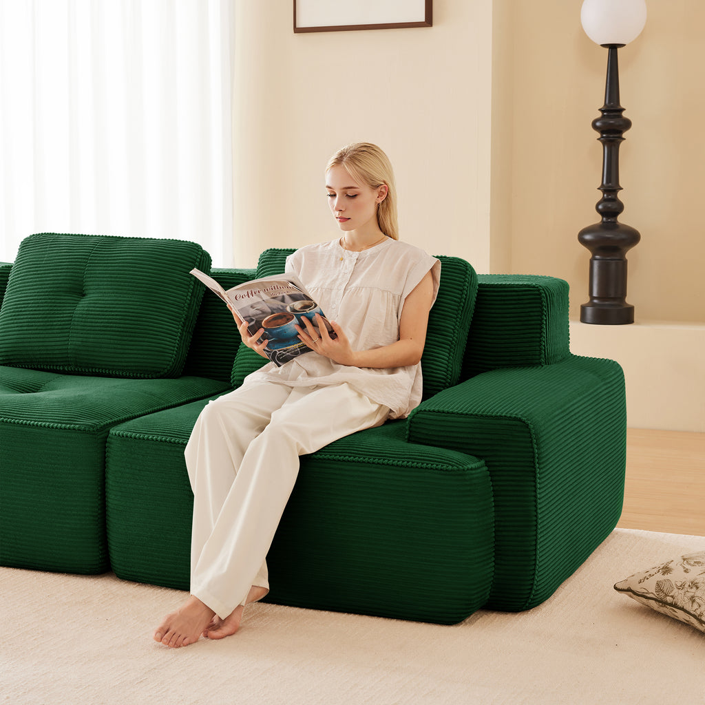Green corduroy modular sectional with wide arms and lounge seating