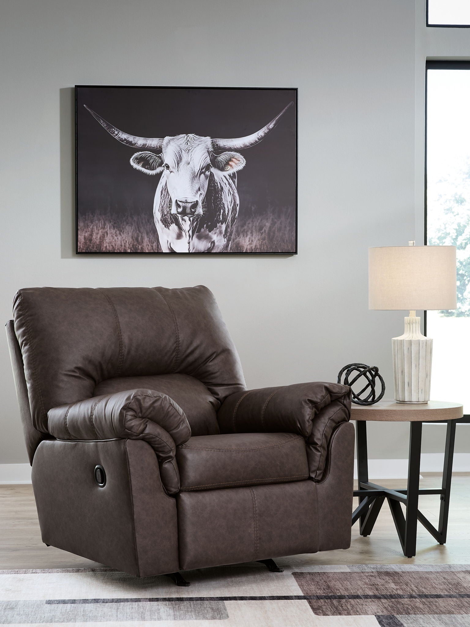 Dark umber upholstered rocker recliner with tufted headrest and roll arm detail