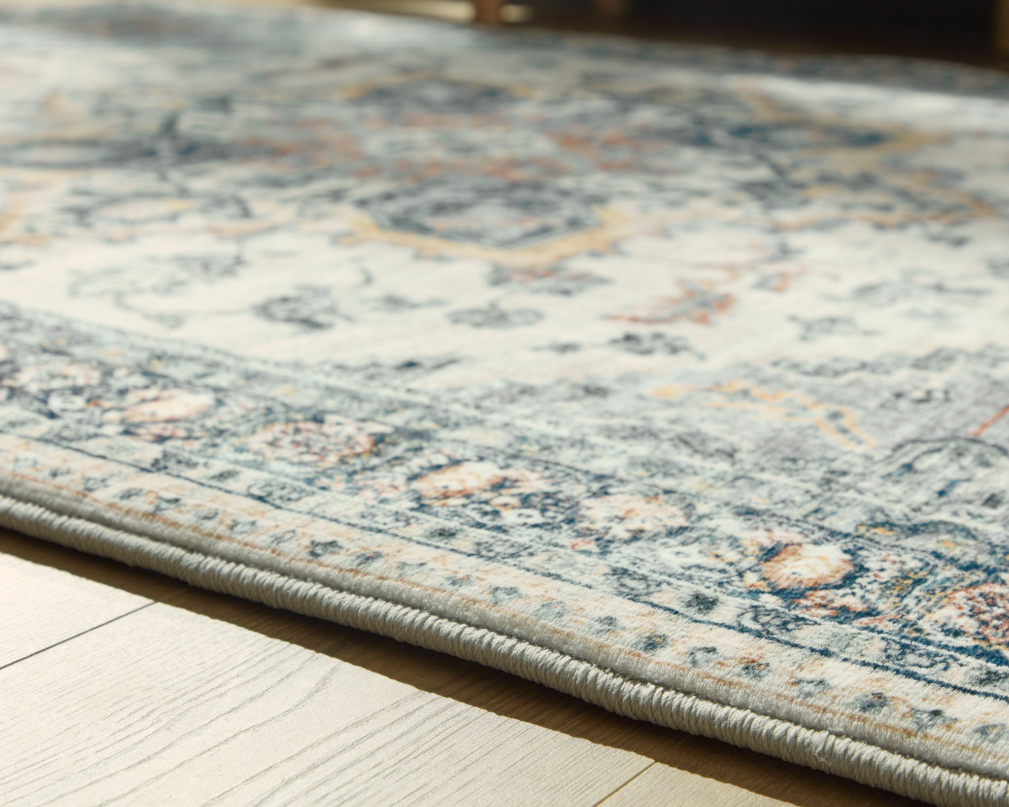 Wallney rug close-up of faded cream and blue patterned surface