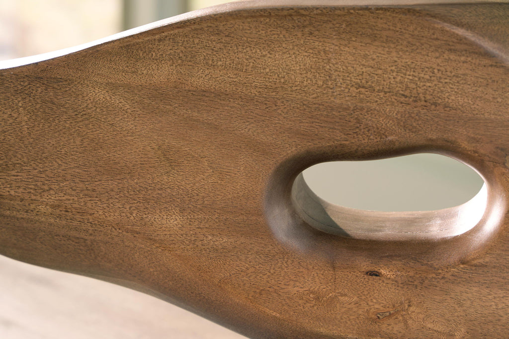 Light brown wooden sculpture surface with oval opening and brushed metal insert