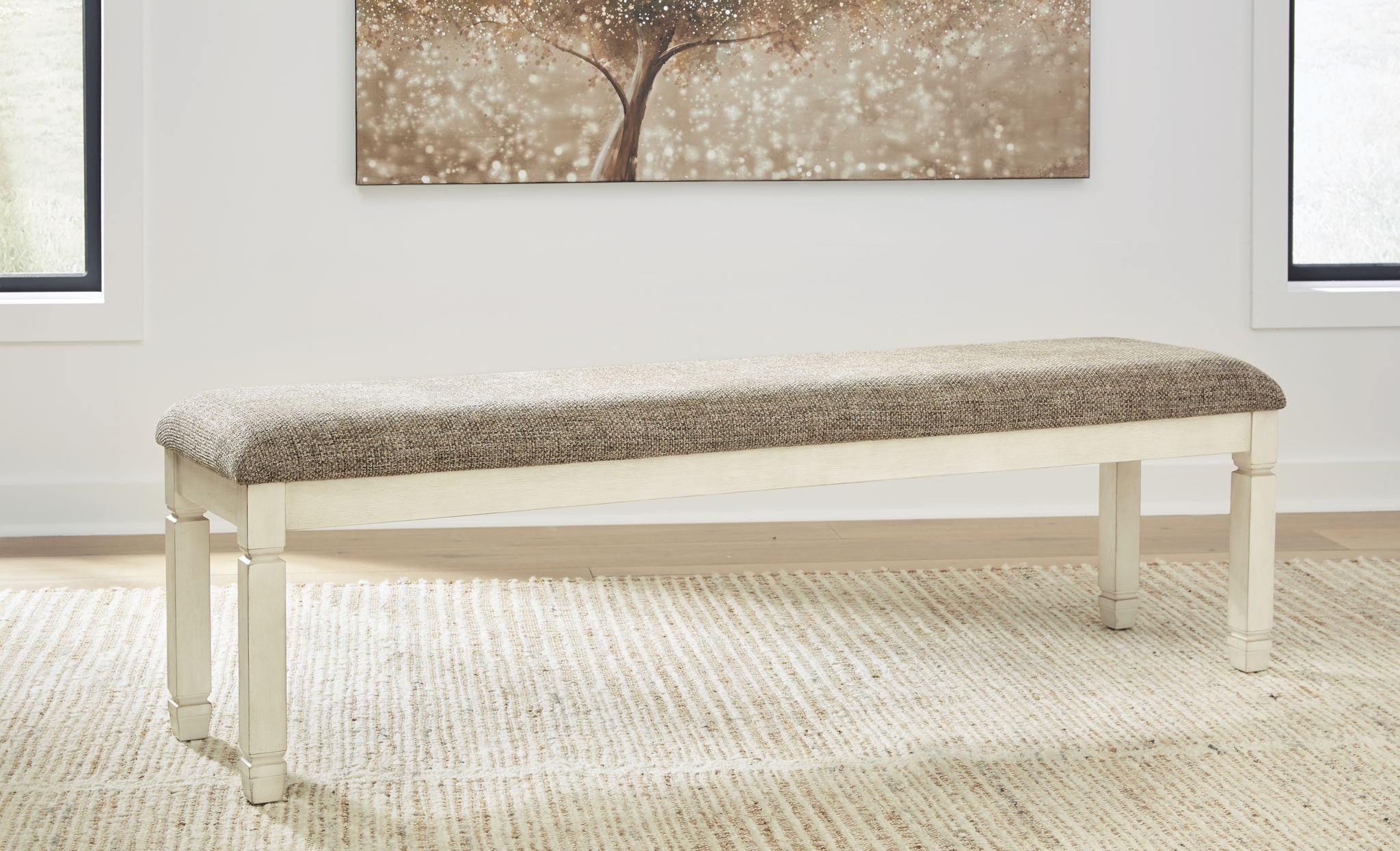 Upholstered dining bench with beige fabric and white turned legs