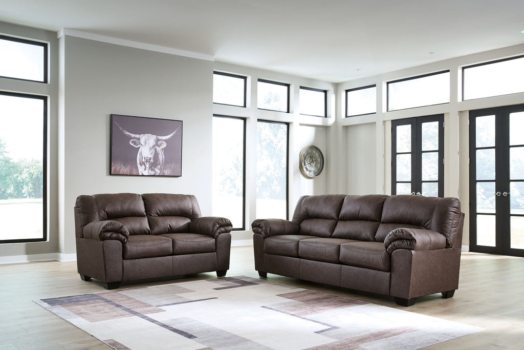 Upholstered living room sofa and recliner set in dark brown with tufted back cushions.