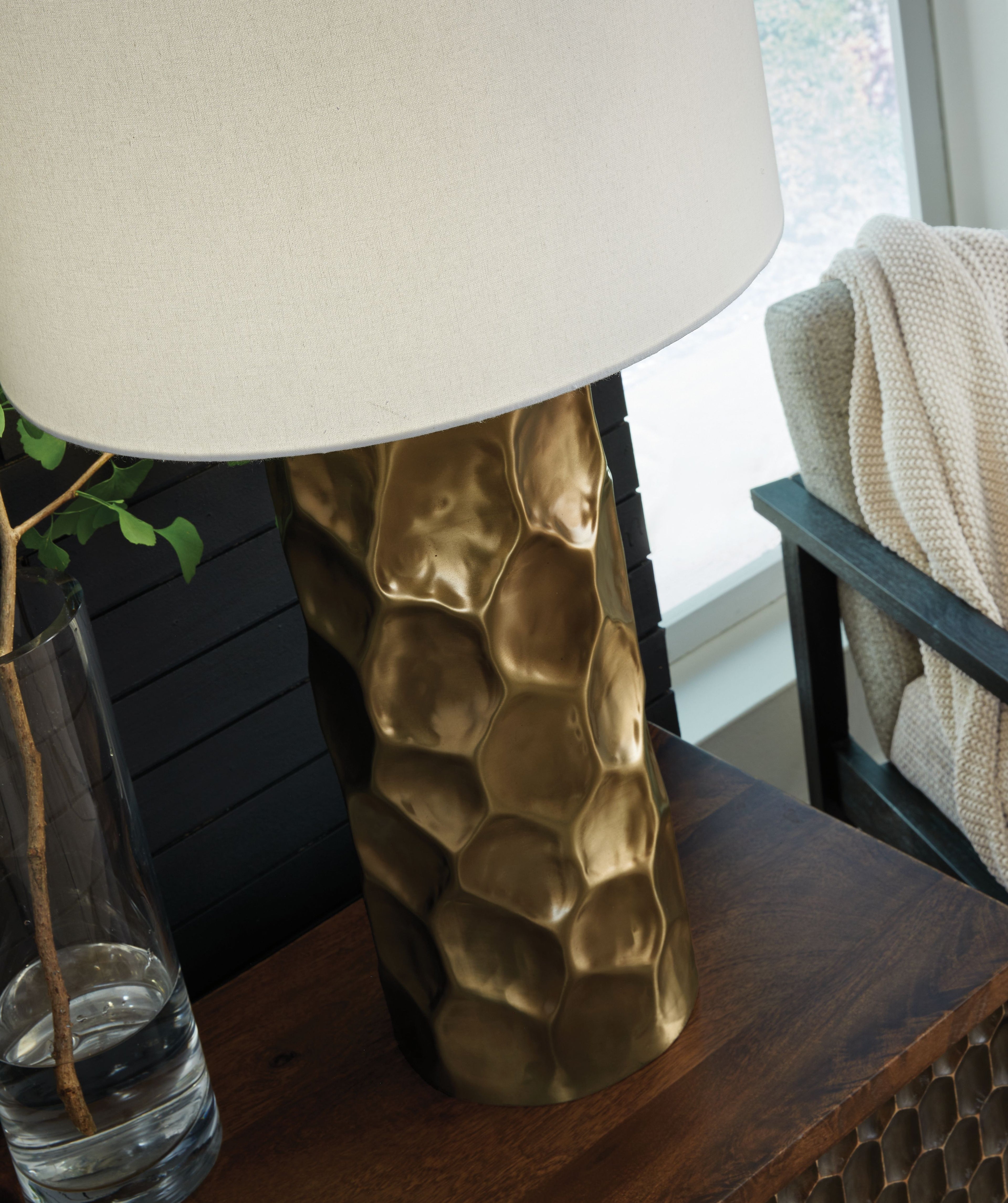 Gold textured table lamp body with white drum shade, shown from an angled view