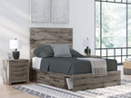 Dark gray storage bed with slatted headboard and two drawers beneath, made with bedding