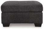 Charcoal gray fabric ottoman with cushioned top, straight sides, and black legs