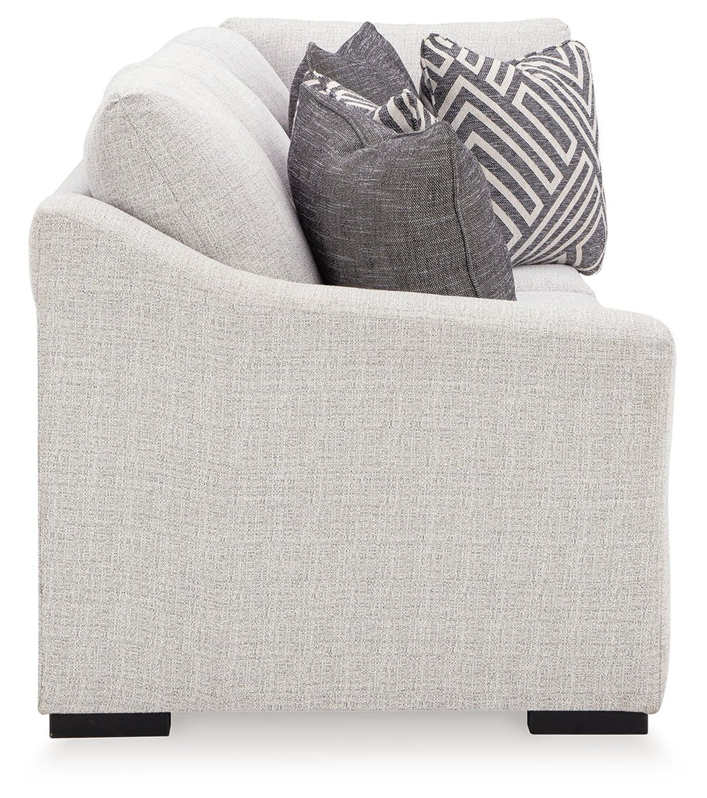 Stone beige sofa with corner wedge and dark patterned throw pillows