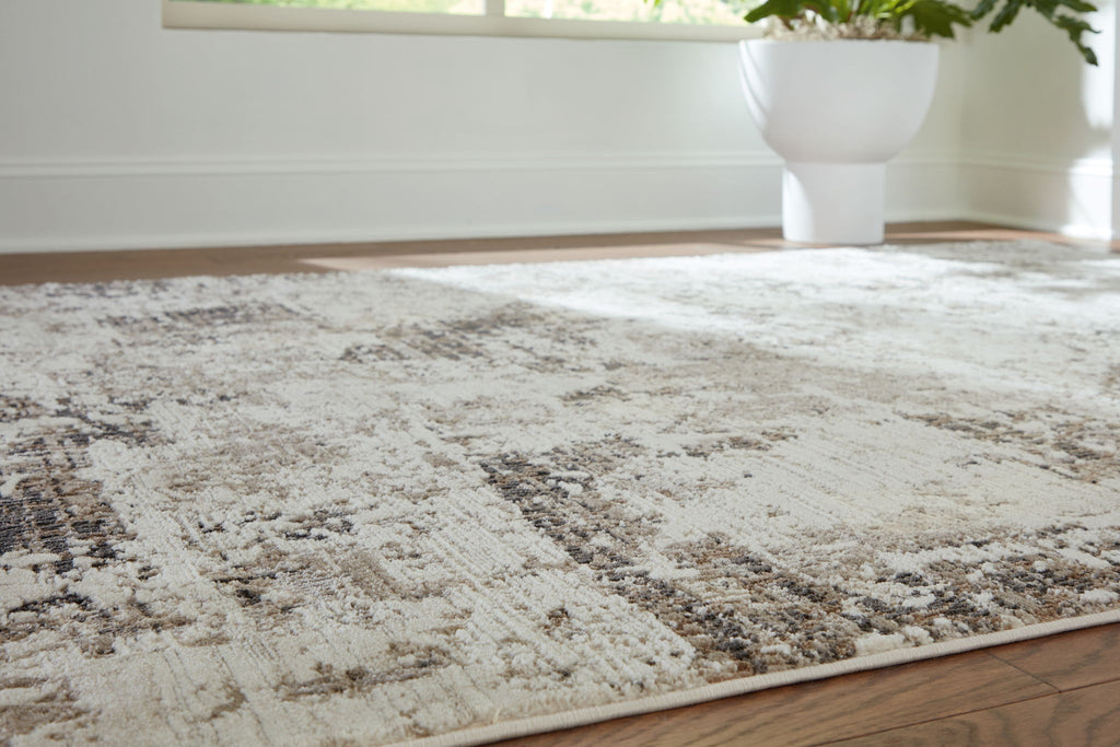 Distressed gray-and-beige area rug laid on the floor, visible abstract pattern.