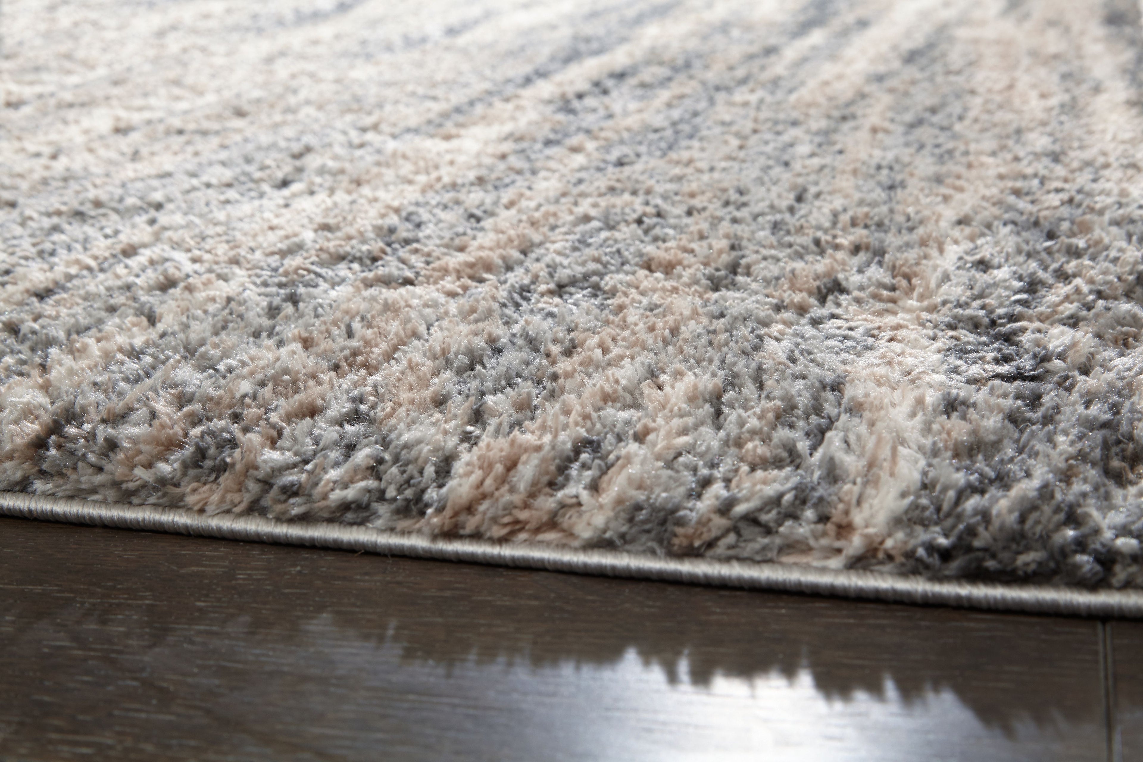 Textured shag rug with mixed gray and beige fibers along the edge