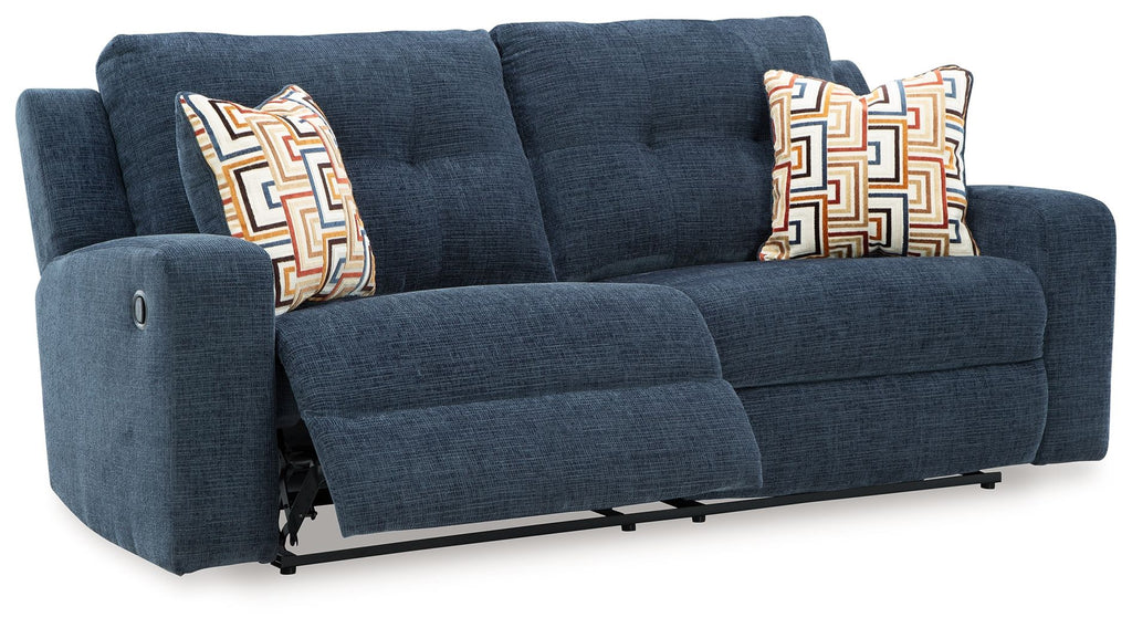 Ink blue 2-seat reclining sofa with three back cushions and patterned throw pillows