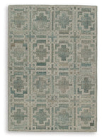 Green geometric area rug with grid of interlocking square patterns
