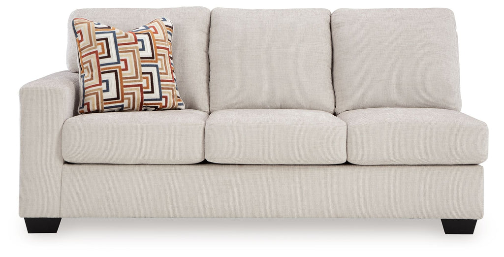 Stone fabric sofa with boxy arms, three seat cushions, and patterned decorative pillow