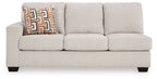 Stone fabric sofa with boxy arms, three seat cushions, and patterned decorative pillow
