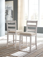 Pair of weathered gray barstools with beige upholstered seats
