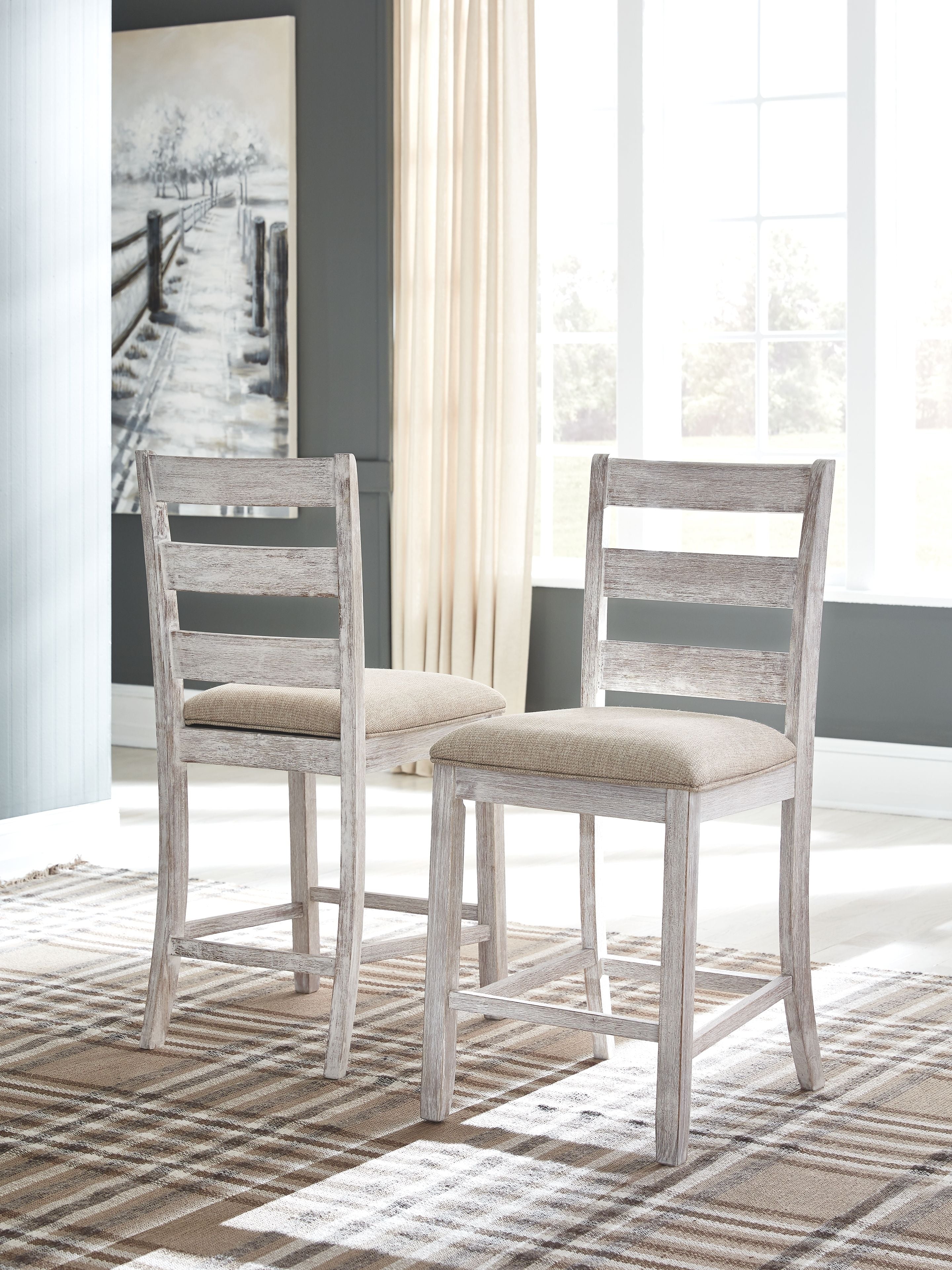 Pair of weathered gray barstools with beige upholstered seats