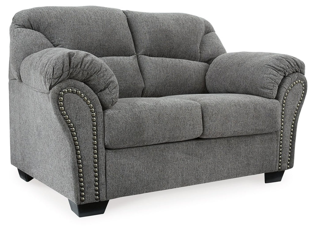 Pewter gray loveseat side view with padded roll arms and studded trim