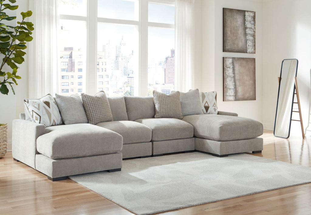 Gray sectional sofa with chaise corner and matching ottoman, styled with patterned throw pillows