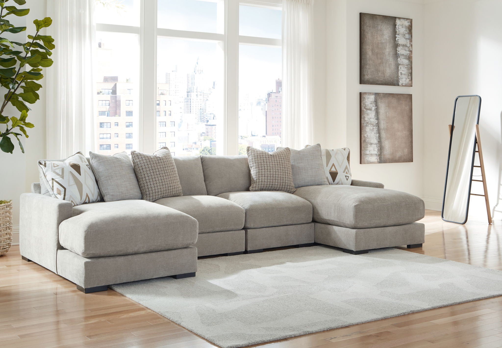 Gray sectional sofa with chaise corner and matching ottoman, styled with patterned throw pillows