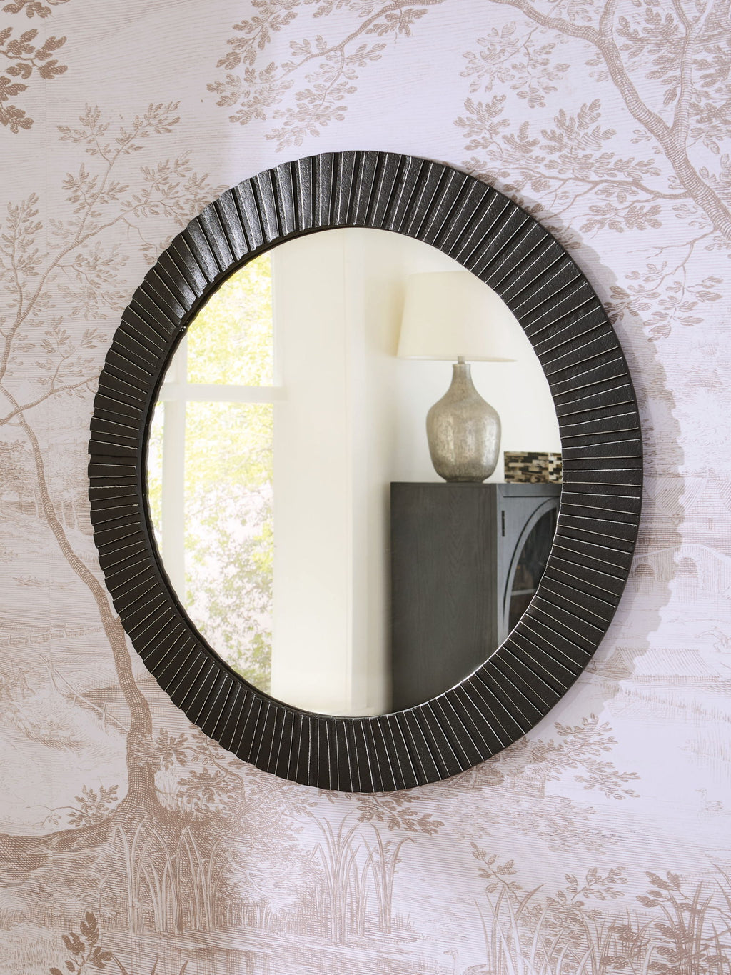 Black round accent mirror with ribbed frame and reflective glass, wall-mounted