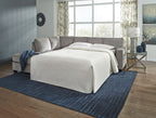 Grey sofa sleeper with white mattress pulled out and two throw pillows