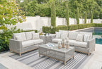 Gray woven outdoor lounge set with two sofas, cushions, and coffee table