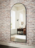 Sethall black arched floor mirror with thin frame, viewed at an angle