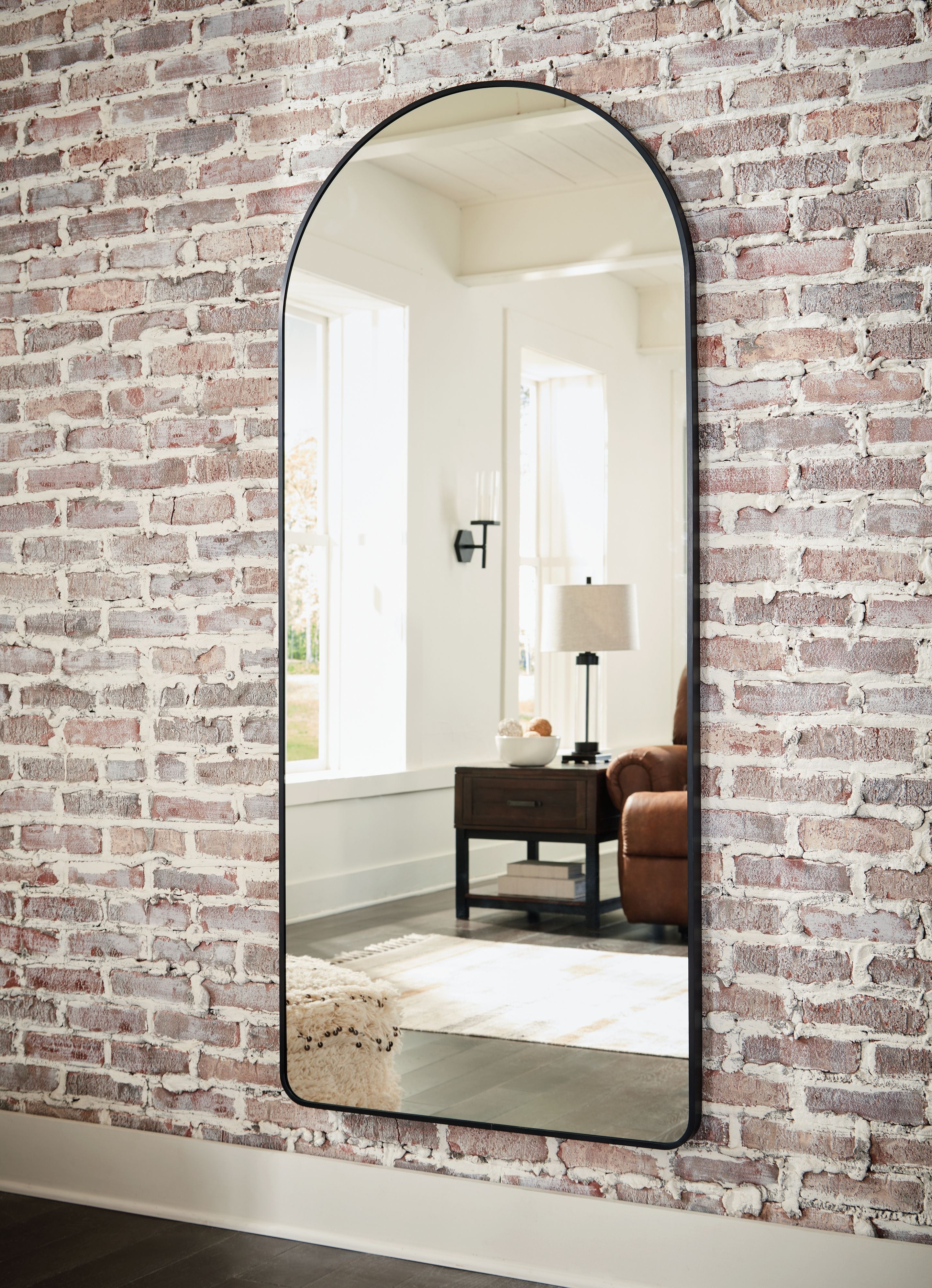 Sethall black arched floor mirror with thin frame, viewed at an angle