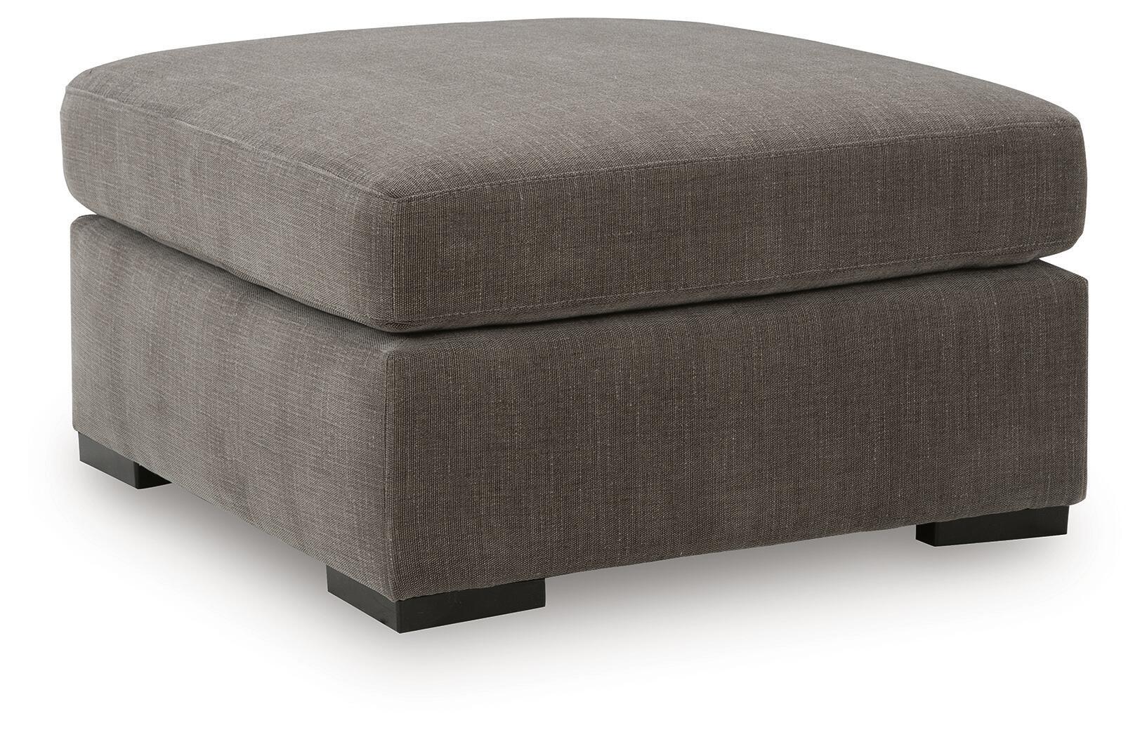 Gray upholstered accent ottoman with cushioned top and square base with block legs