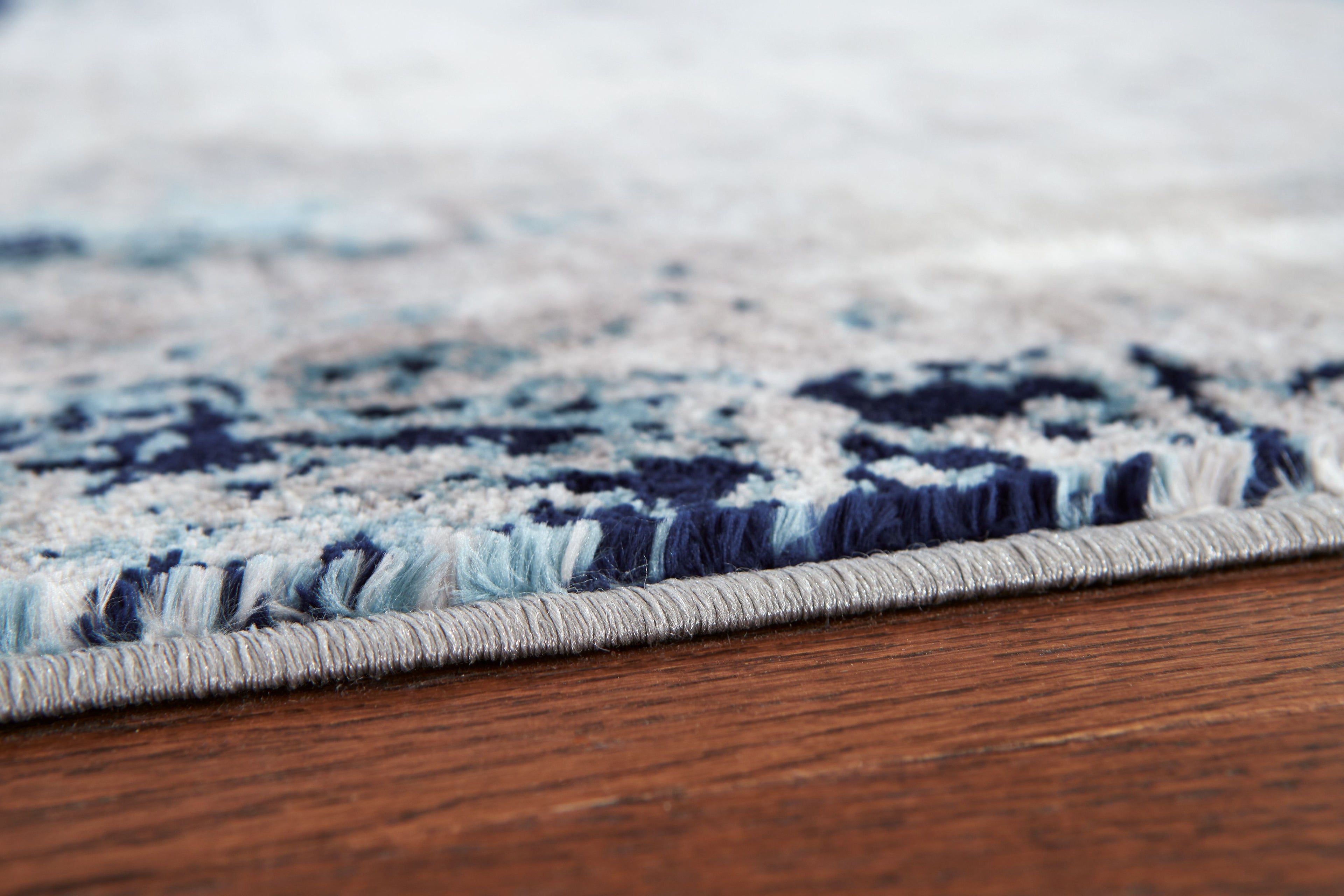 Blue and gray rug border with short fringe and textured pile