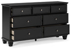 Black dresser with six drawers and round silver knobs, angled view showing side panel