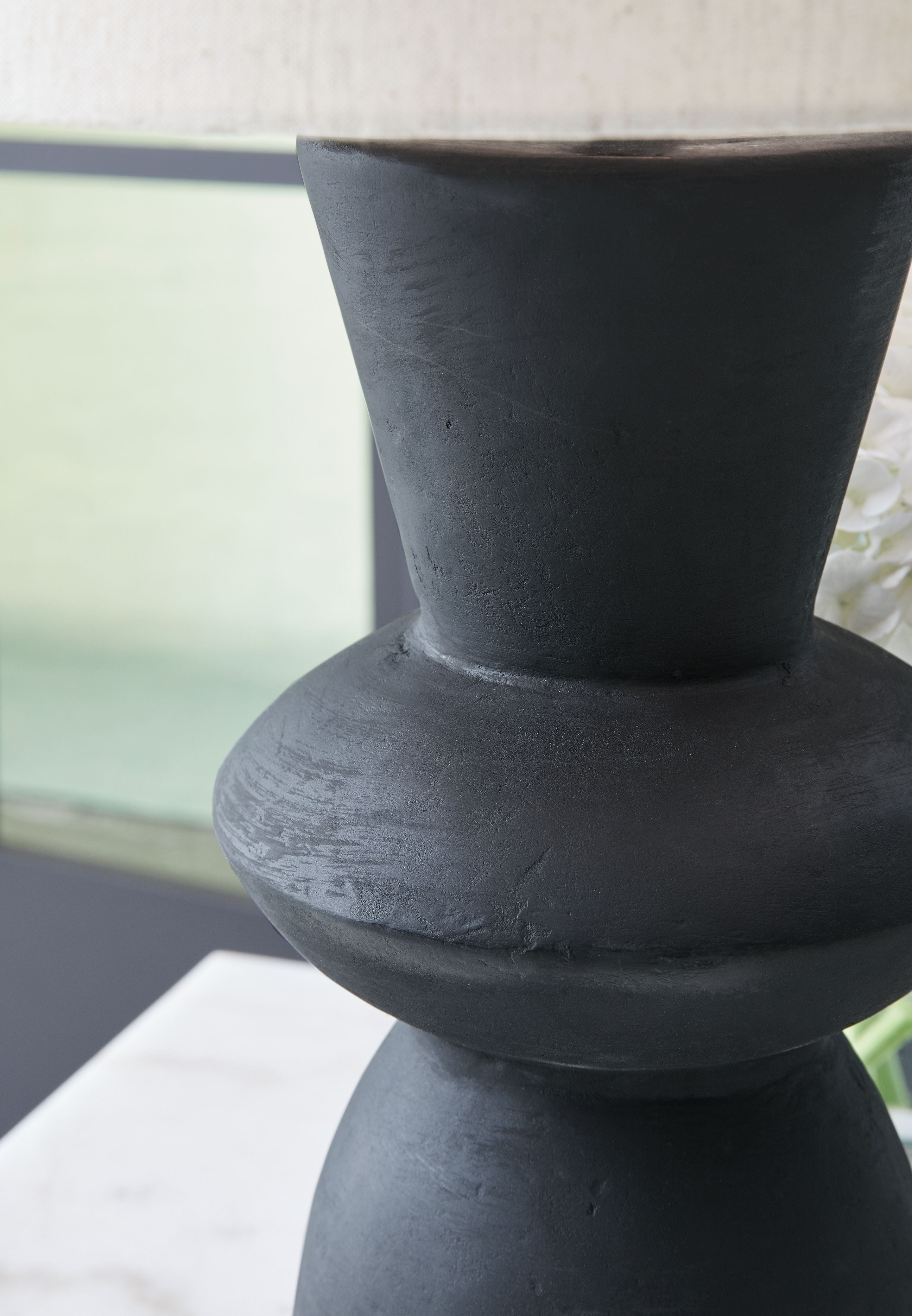 Distressed black hourglass table lamp base with drum shade edge