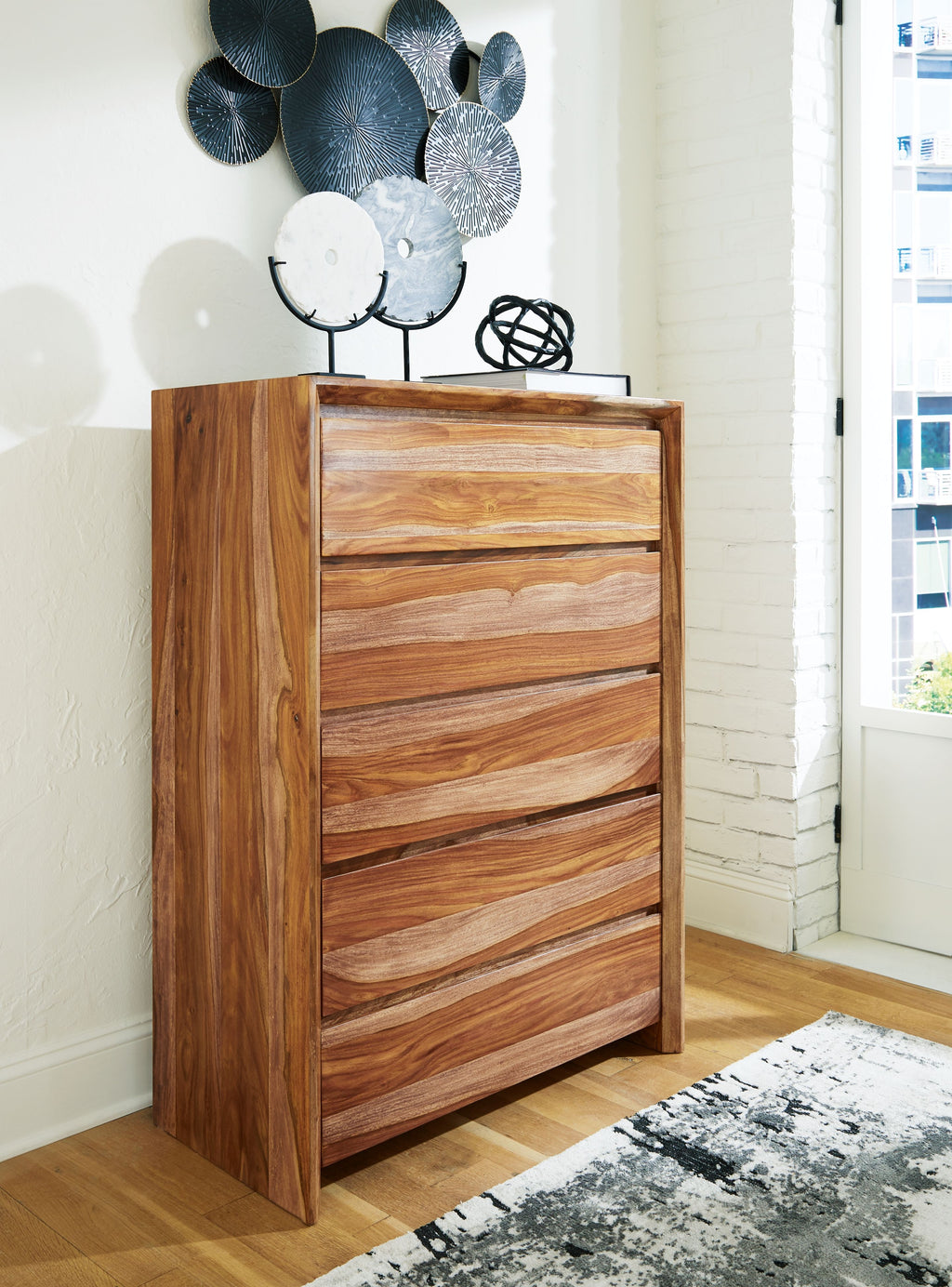 Five-drawer wooden chest in brown with decorative metal pieces on top