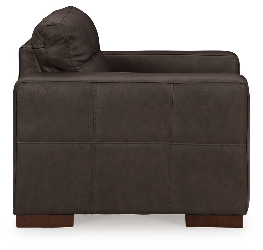 Dark brown upholstered chair with rounded back cushion, stitched panels, and armrests