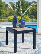 Blue rectangular cocktail table with slatted beige top, dark frame, and vase decor