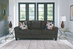 Dark gray sofa with three seat cushions and patterned throw pillows