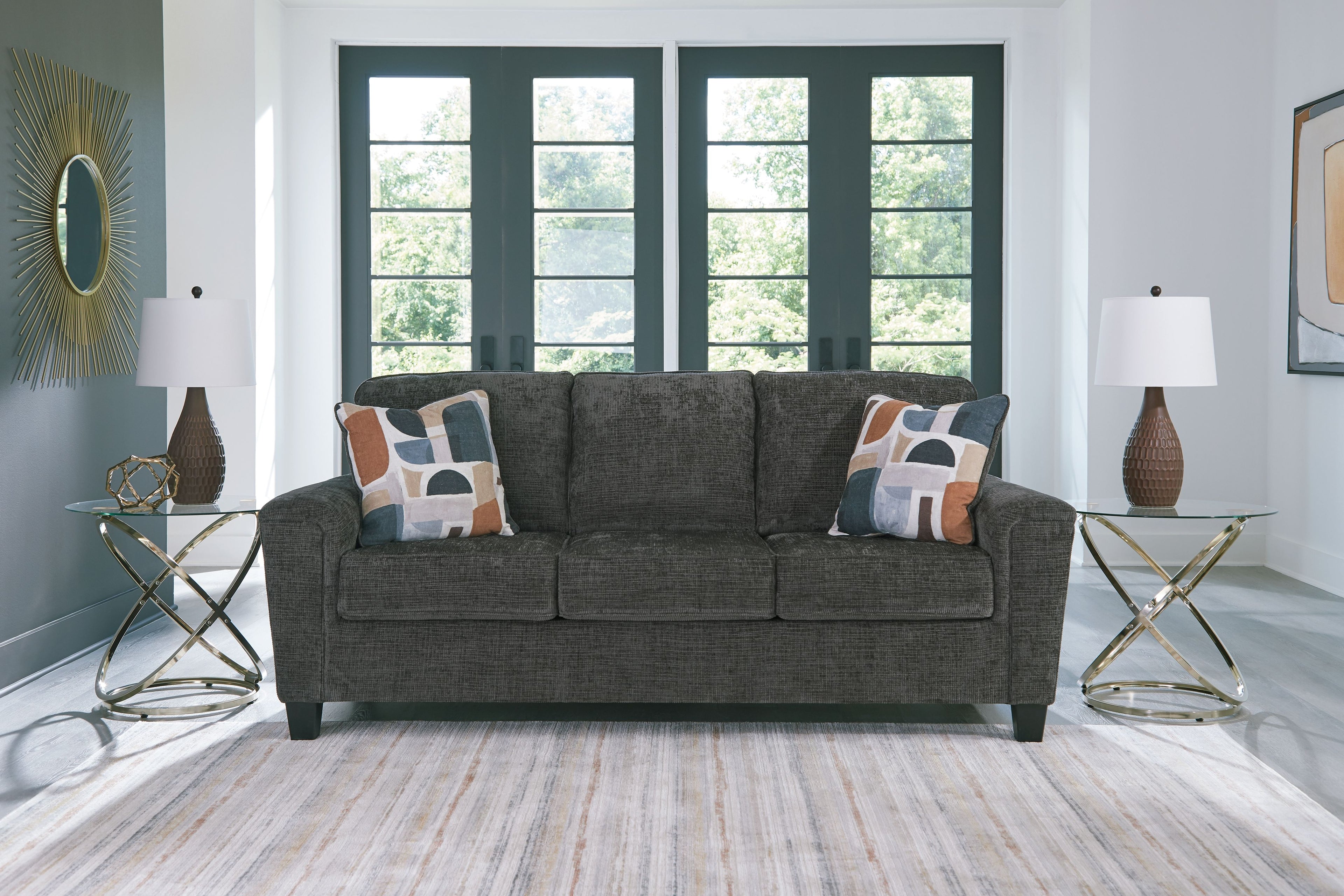 Dark gray sofa with three seat cushions and patterned throw pillows