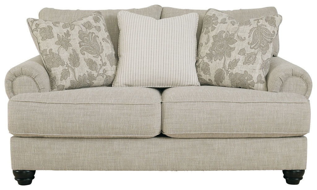 Fog light gray loveseat with three accent pillows, striped center and patterned sides.