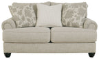 Fog light gray loveseat with three accent pillows, striped center and patterned sides.