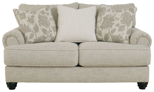 Fog light gray loveseat with three accent pillows, striped center and patterned sides.