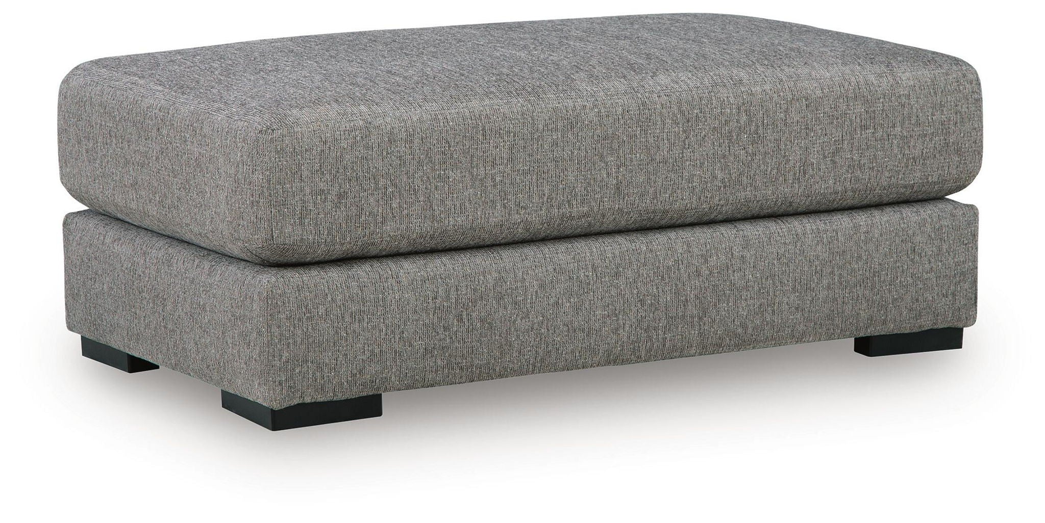 Grey upholstered oversized ottoman with wide cushioned top and tapered legs