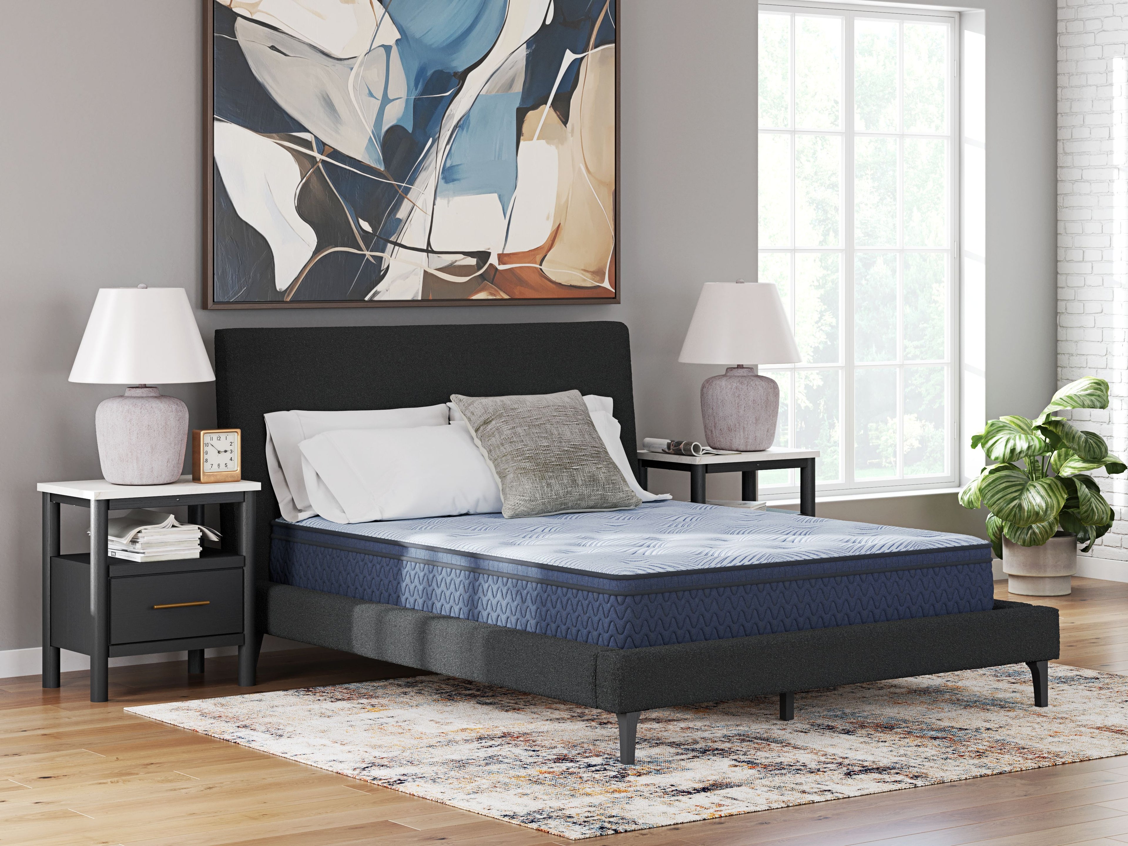 Blue hybrid mattress with quilted top, shown on bed frame with pillows