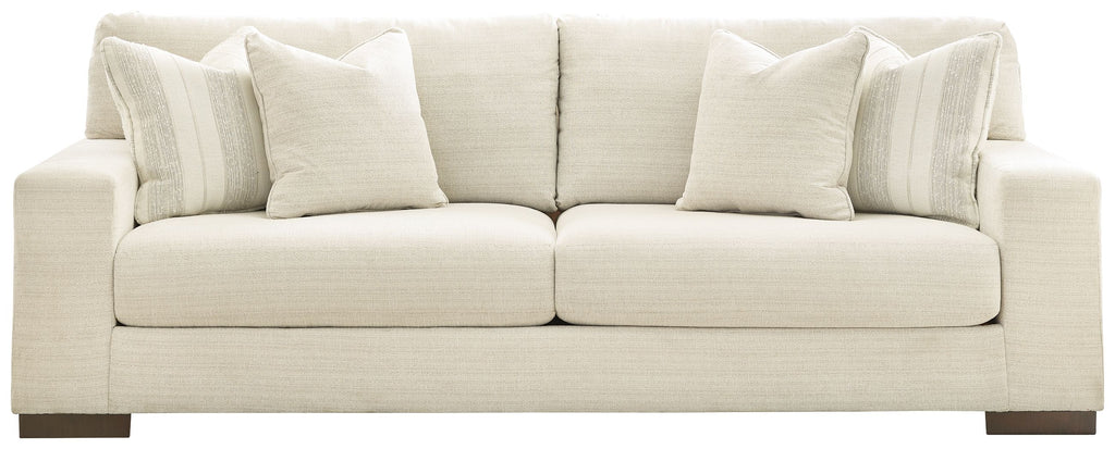 Light beige sofa with padded seat cushions and multiple back pillows