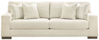 Light beige sofa with padded seat cushions and multiple back pillows