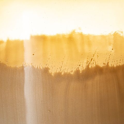 Close-up of ombre amber and ivory vase glaze with textured horizontal band