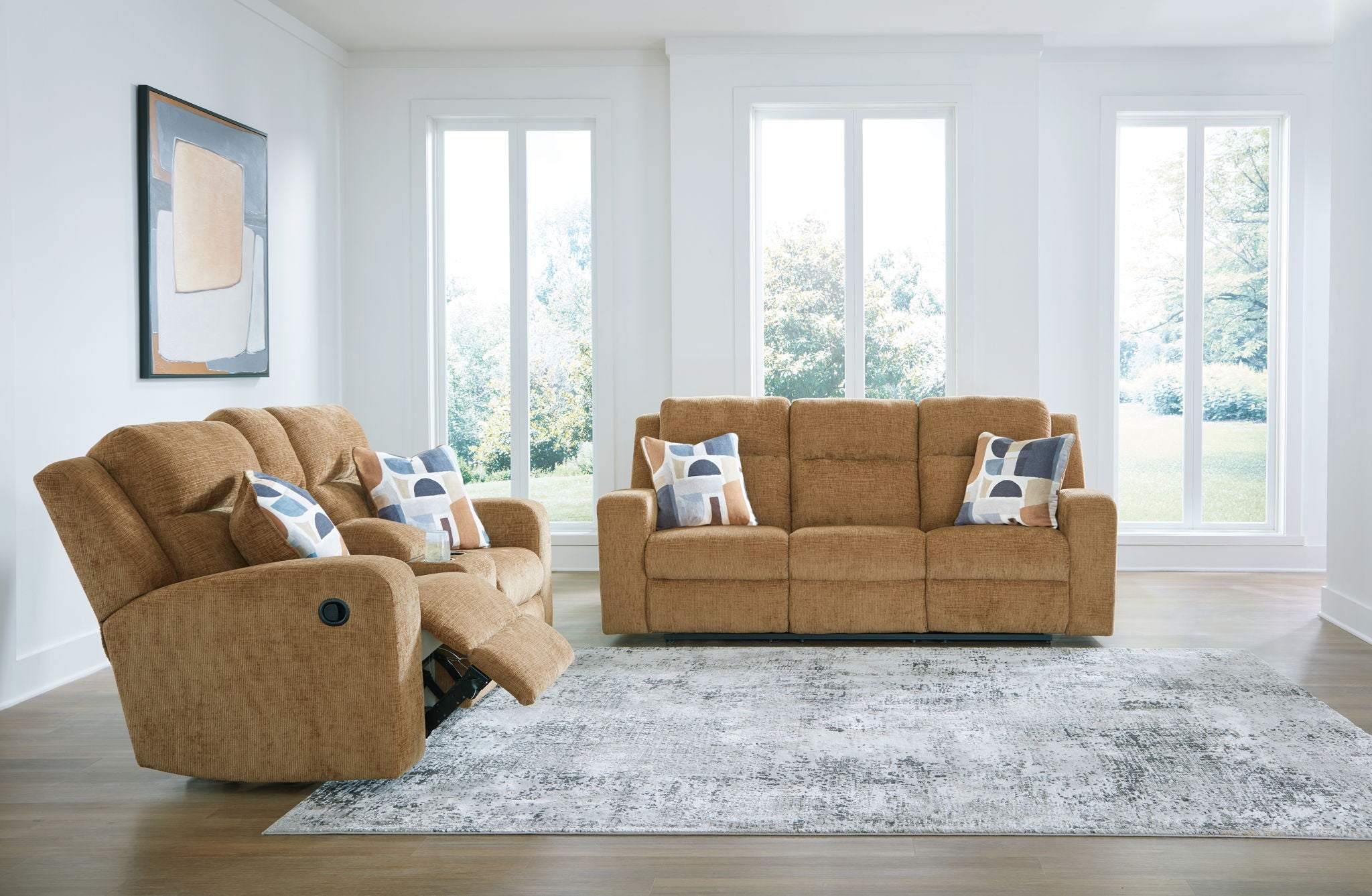 Light brown reclining sofa and matching recliner with blue patterned pillows